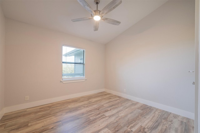 empty room featuring ceiling fan, vaulted ceiling, and light wood-type flooring