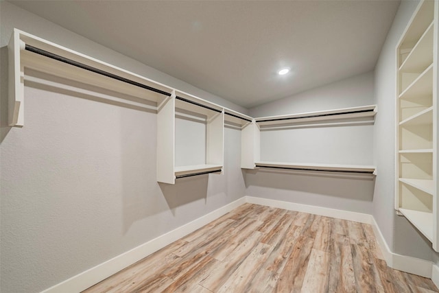 spacious closet featuring light wood-type flooring and vaulted ceiling