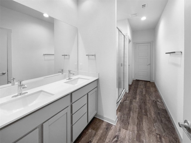 bathroom featuring wood-type flooring, vanity, and a shower with shower door