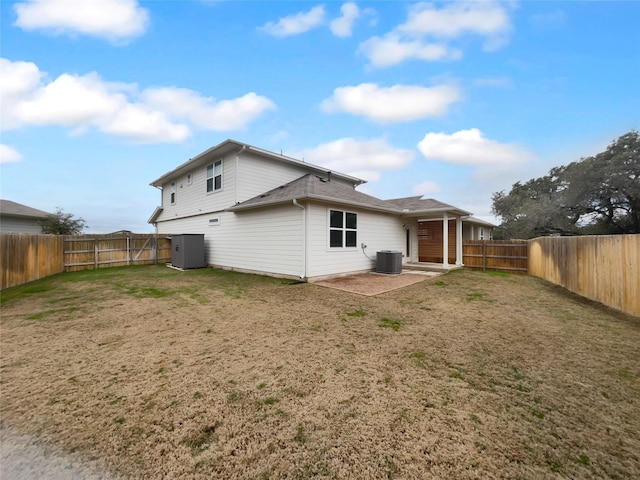 back of property with a patio area, a yard, and cooling unit