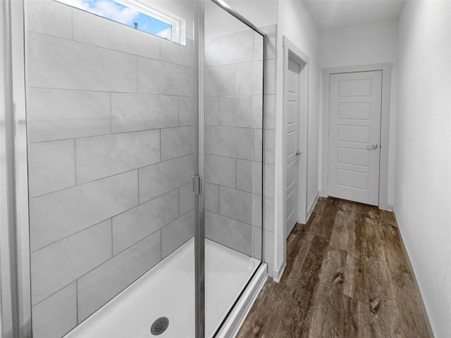 bathroom with an enclosed shower and wood-type flooring