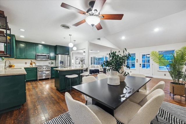 dining room with ceiling fan, lofted ceiling, dark hardwood / wood-style floors, and sink