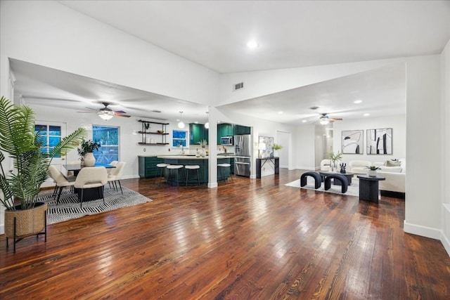 living room with ceiling fan, dark hardwood / wood-style floors, and vaulted ceiling