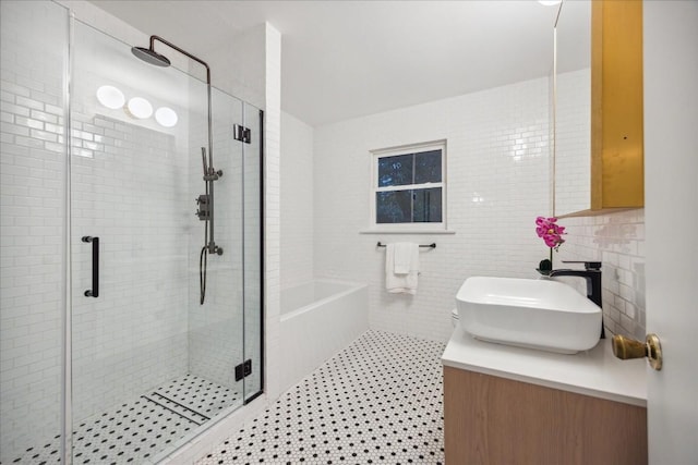 bathroom with vanity, tile patterned flooring, independent shower and bath, and tile walls