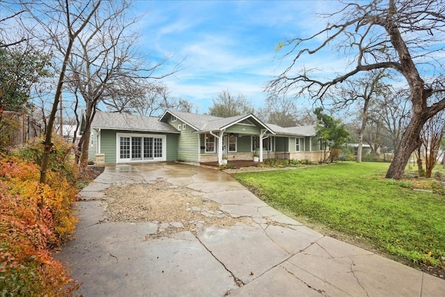 ranch-style house featuring a front yard and covered porch