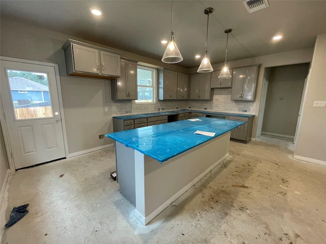 kitchen featuring hanging light fixtures, gray cabinetry, tasteful backsplash, and a kitchen island