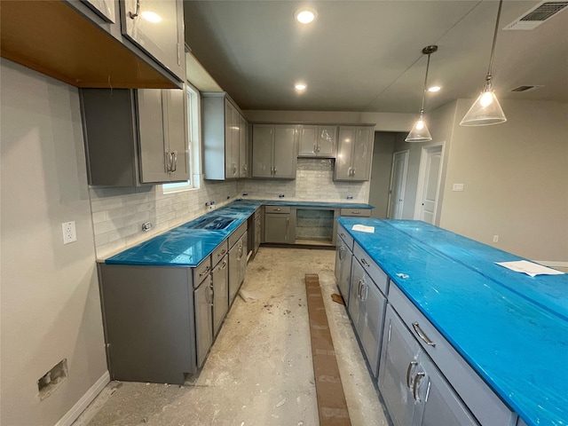 kitchen with backsplash, gray cabinets, and pendant lighting