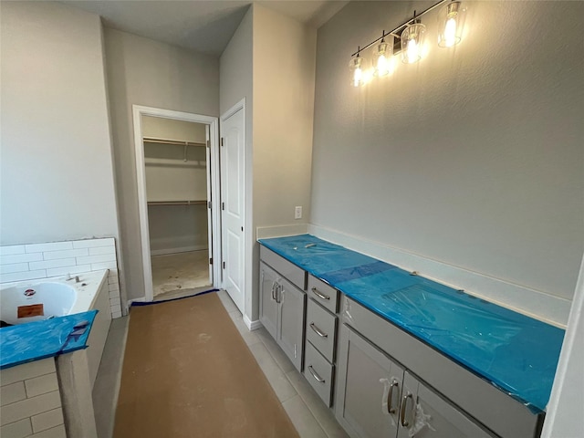 bathroom featuring vanity, tile patterned flooring, and a washtub