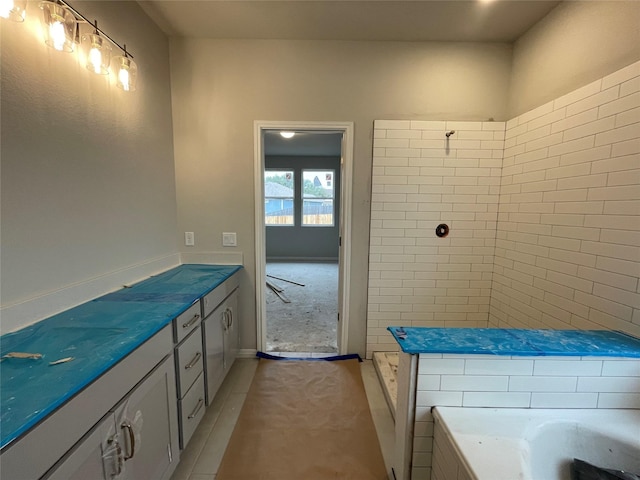 bathroom with tile patterned flooring and a bath