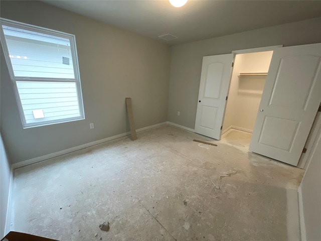 unfurnished bedroom featuring a closet and a walk in closet