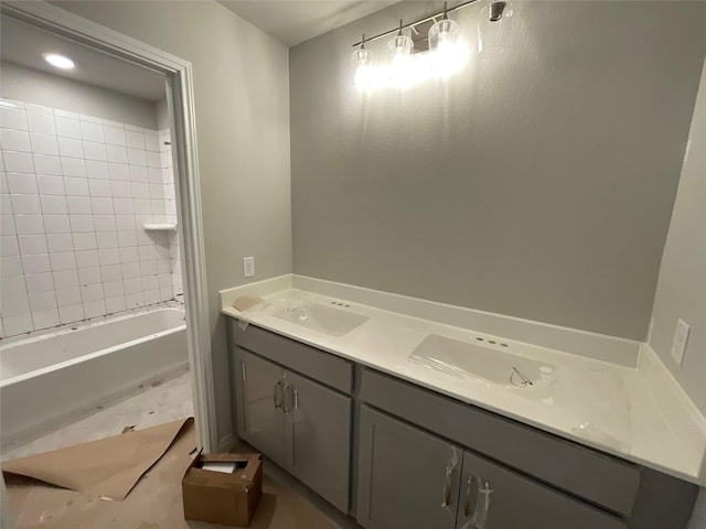 bathroom with tiled shower / bath and vanity