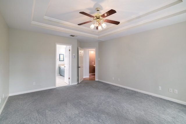 empty room featuring light colored carpet, a raised ceiling, ceiling fan, and ornamental molding