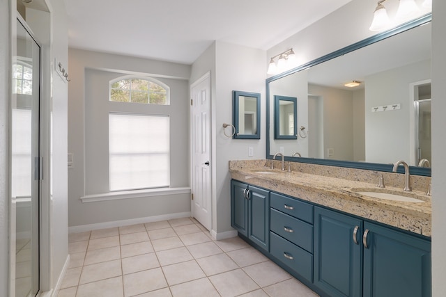 bathroom featuring tile patterned flooring, vanity, and walk in shower