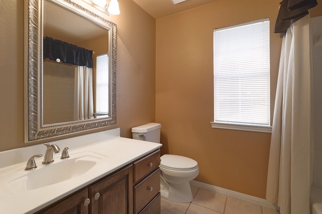 bathroom featuring tile patterned floors, vanity, a healthy amount of sunlight, and toilet