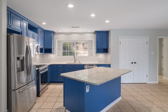857 Mission Hills Dr, New Braunfels, TX 78130 - kitchen with stainless steel appliances, blue cabinetry, light tile patterned floors, decorative backsplash, and recessed lighting