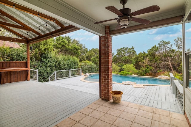 view of swimming pool with ceiling fan and a deck