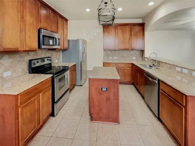 kitchen with decorative backsplash, light stone counters, sink, and appliances with stainless steel finishes