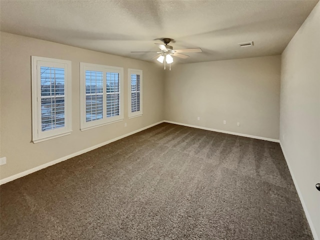 unfurnished room featuring dark colored carpet, ceiling fan, and a textured ceiling