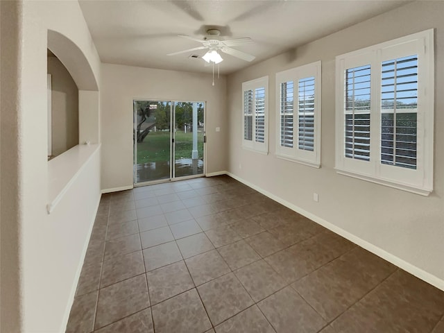 tiled empty room featuring ceiling fan