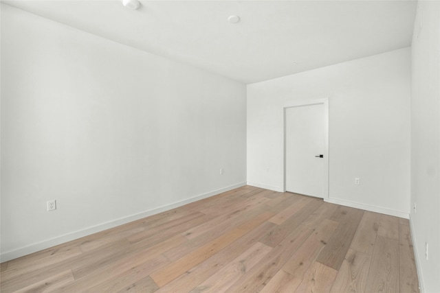 empty room with light wood finished floors and baseboards