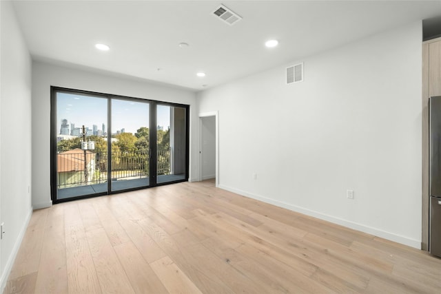 empty room featuring visible vents, recessed lighting, baseboards, and light wood-style floors