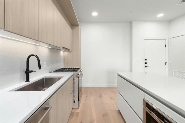 kitchen featuring visible vents, decorative backsplash, stainless steel appliances, modern cabinets, and a sink