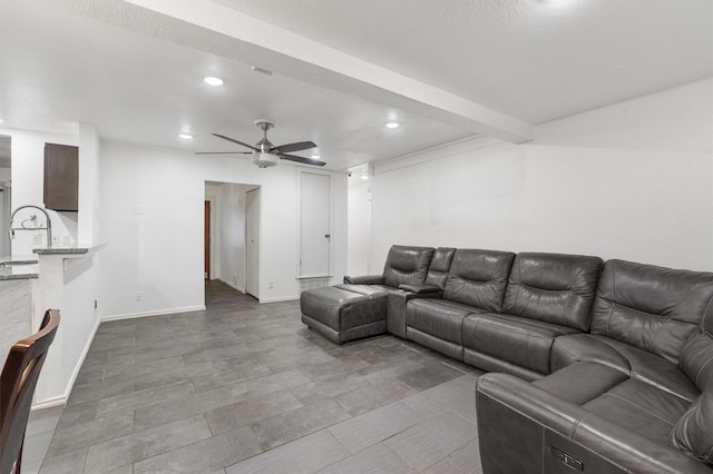 living room featuring ceiling fan, beam ceiling, and sink