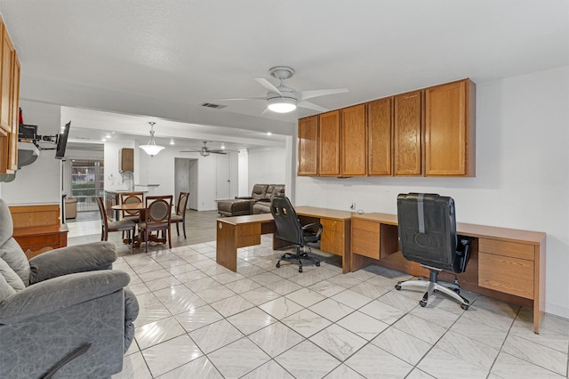 home office with ceiling fan and built in desk