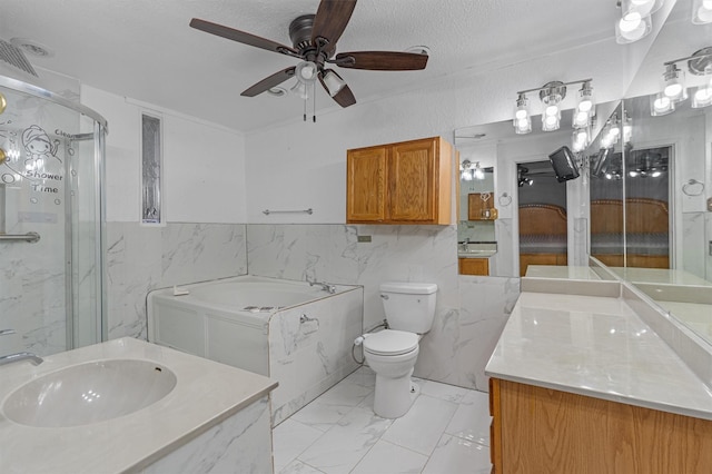 full bathroom with vanity, ceiling fan, toilet, shower with separate bathtub, and a textured ceiling