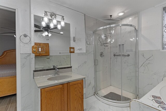 bathroom featuring ceiling fan, vanity, a textured ceiling, and walk in shower