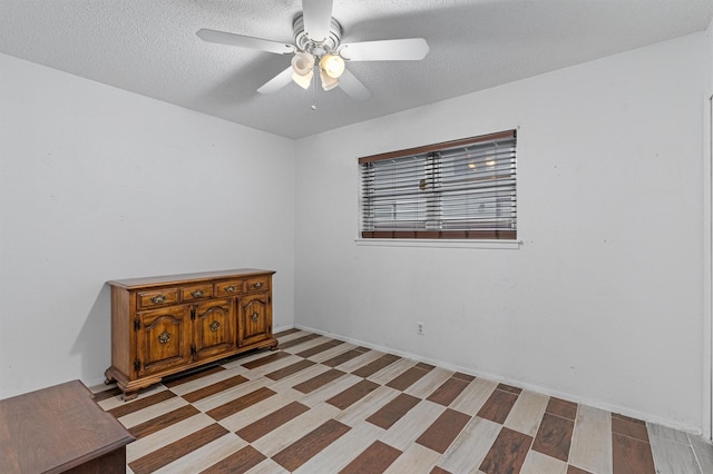 spare room with ceiling fan and a textured ceiling