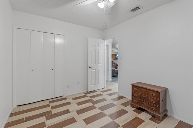 unfurnished bedroom featuring ceiling fan, a closet, and a textured ceiling