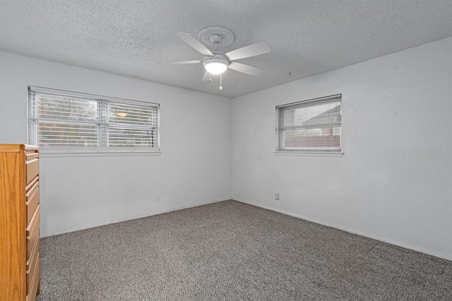 carpeted spare room with a textured ceiling and ceiling fan