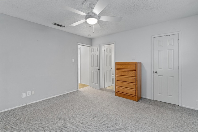 unfurnished bedroom with light carpet, a textured ceiling, and ceiling fan