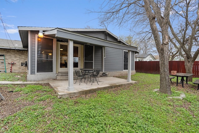 rear view of house featuring a yard and a patio