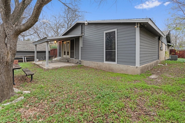 back of house with a lawn, cooling unit, and a patio