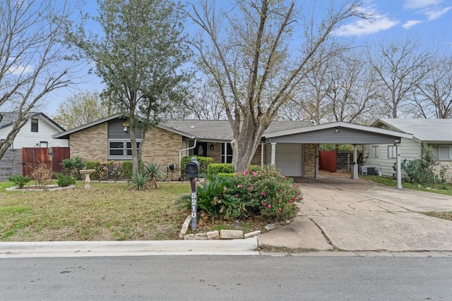5210 Gladstone Dr, Austin, TX 78723 - view of front of house featuring a carport, concrete driveway, a garage, and brick siding