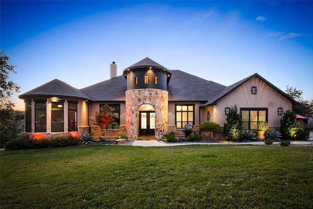 view of front of property with french doors and a yard