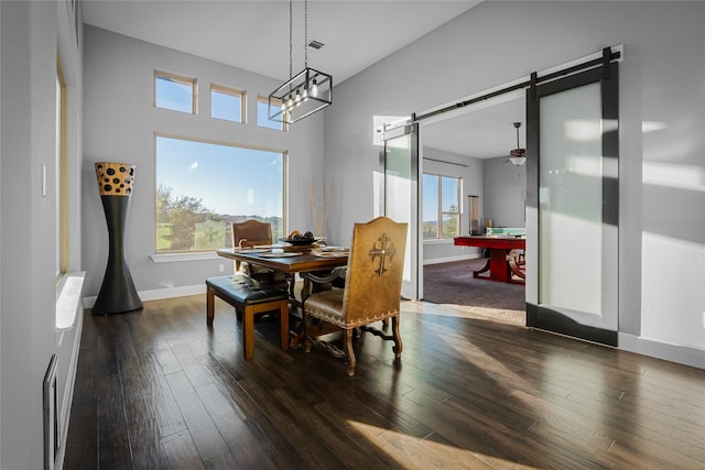 dining area with a barn door, ceiling fan, dark wood-type flooring, and billiards