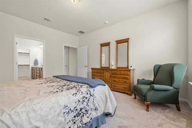 bedroom with a walk in closet, a closet, and carpet