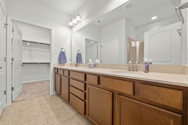 bathroom with tile patterned floors, vanity, and walk in shower