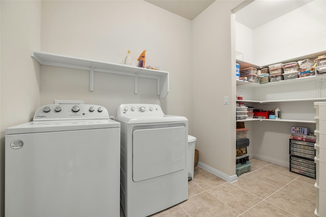 washroom with light tile patterned floors and washer and clothes dryer