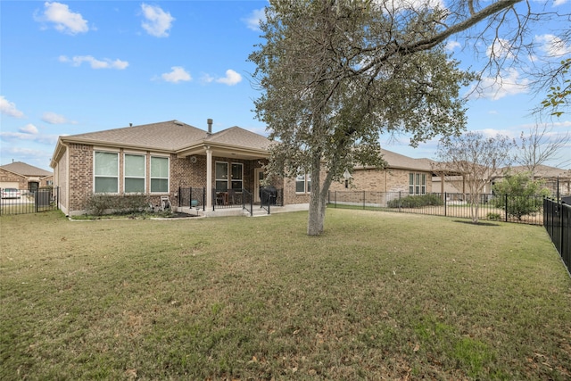 rear view of house featuring a yard and a patio