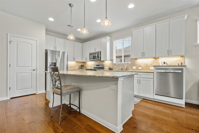 kitchen featuring white cabinetry, a kitchen island, and appliances with stainless steel finishes