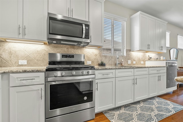 kitchen with stainless steel appliances, white cabinetry, dark hardwood / wood-style floors, and sink