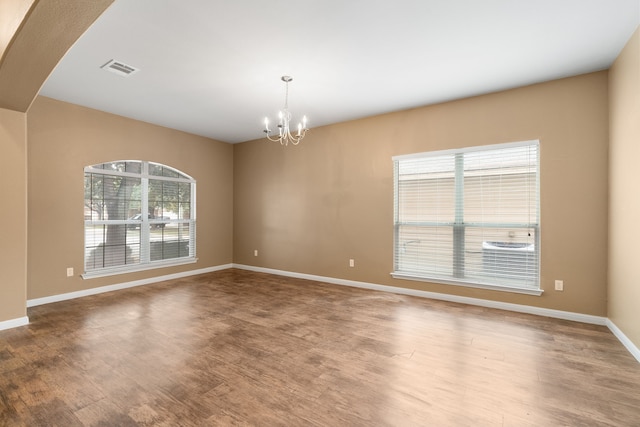 empty room featuring hardwood / wood-style floors and an inviting chandelier