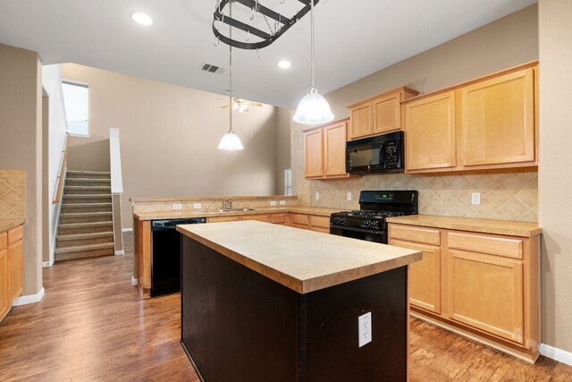 kitchen with sink, decorative light fixtures, light brown cabinetry, a kitchen island, and black appliances