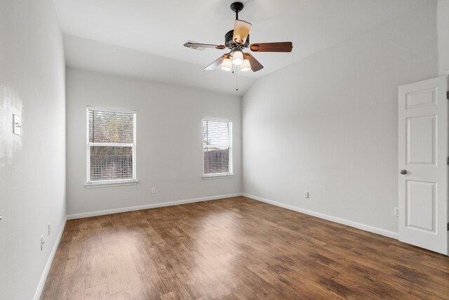 empty room with ceiling fan, dark hardwood / wood-style flooring, and vaulted ceiling