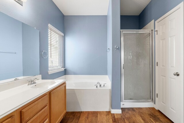 bathroom featuring hardwood / wood-style floors, shower with separate bathtub, and sink