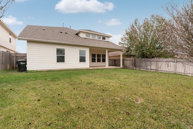 back of property with a patio area and a yard